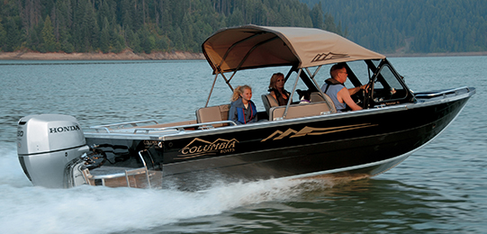 Image of a family fishing in a large boat at sunset